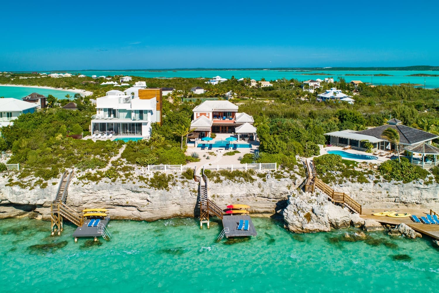 Aerial view of Villa La Percha's dock, stairs, pool, and house on the water
