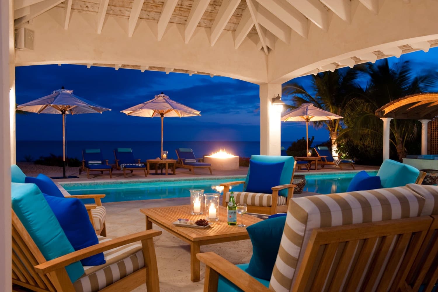 Nighttime pool, pergola, and fire pit at Villa La Percha